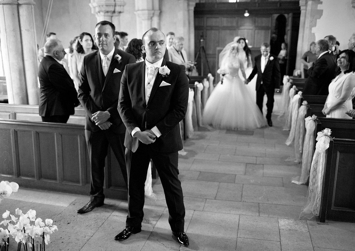The groom waits for the bride in St Michael and All Angels Church in Wadenhoe